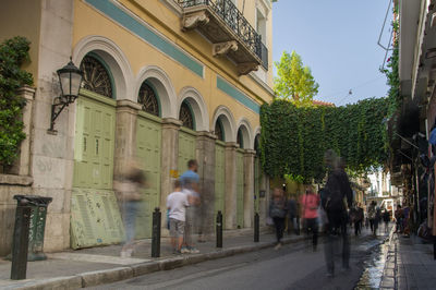 People walking on street amidst buildings in city