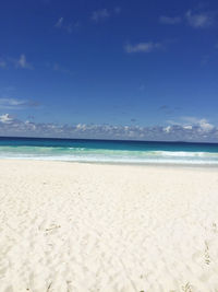 Scenic view of beach against blue sky