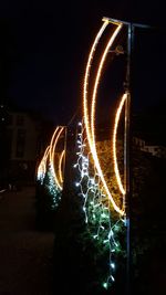 Close-up of illuminated light trails against sky at night