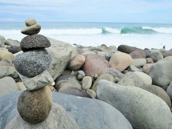 Close-up of pebbles on beach against sky