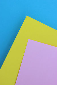 High angle view of yellow colored pencils on blue background