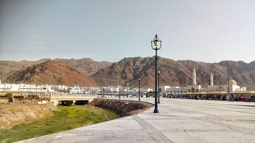 Street by mountains against sky