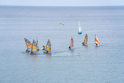 Sailboats in sea against sky
