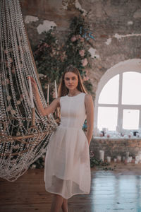 Portrait of woman standing against wall