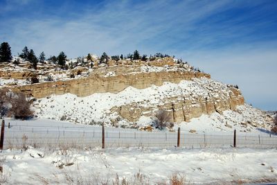 Snow covered landscape against blue sky