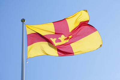 Low angle view of flag against clear blue sky