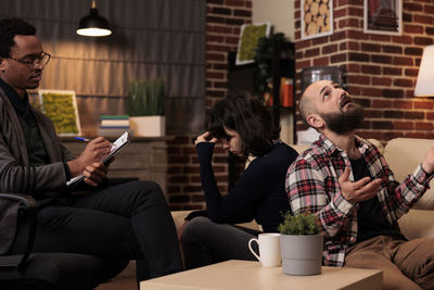 Friends using mobile phone while sitting on table