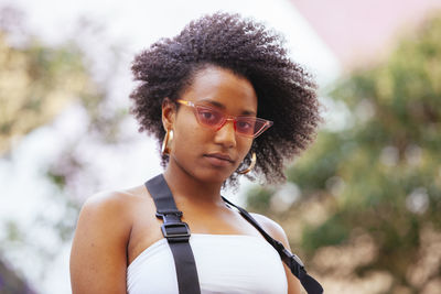 Portrait of young woman wearing sunglasses standing outdoors