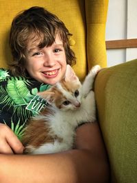 Portrait of smiling young woman with cat