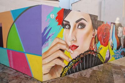 Portrait of young woman against graffiti wall