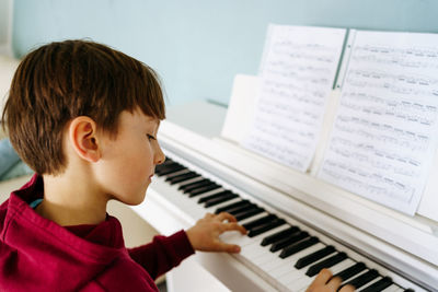 Boy playing piano at home