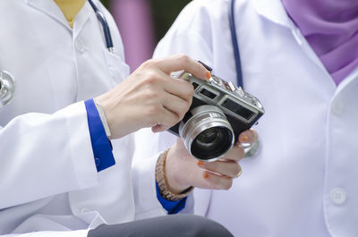 Midsection of man holding camera