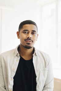 Portrait of male computer programmer standing in office