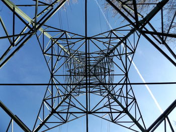 Low angle view of electricity pylon against clear blue sky