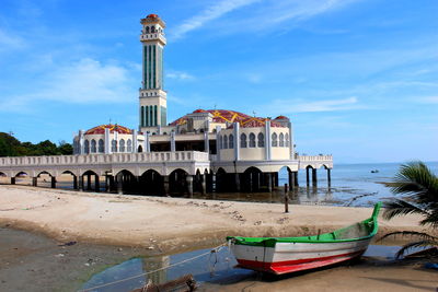 Boats moored in sea against building