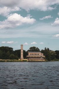 Building by lake against sky