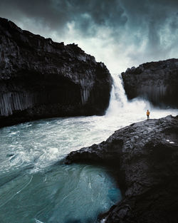 Scenic view of waterfall against sky