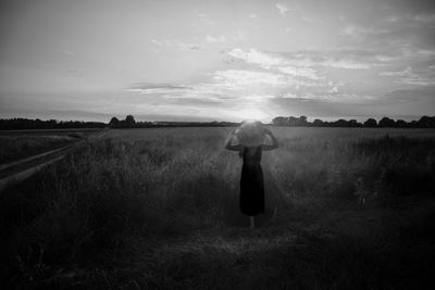 Woman standing on field against sky