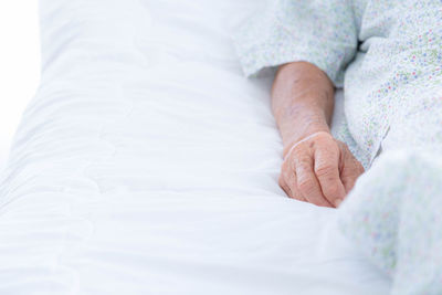 Midsection of woman lying on bed