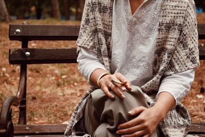 Midsection of woman sitting in park