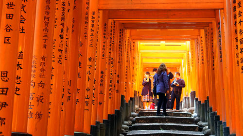 Rear view of people walking on staircase at temple