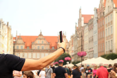 Rear view of woman with arms raised in city