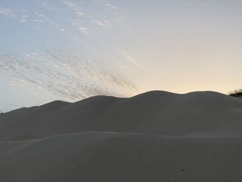 Scenic view of desert against sky during sunset