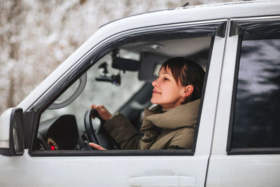 Portrait of woman sitting in car window