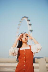 Young woman standing against clear sky