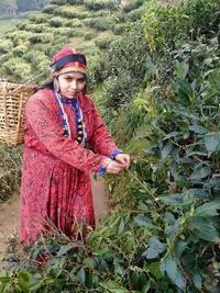 Portrait of woman standing by plants