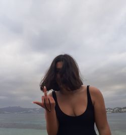 Beautiful woman standing against sea against sky