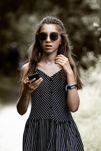 Portrait of girl wearing sunglasses while standing outdoors