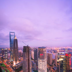 Illuminated buildings in city against sky
