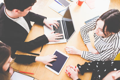 High angle view of people using laptop on table