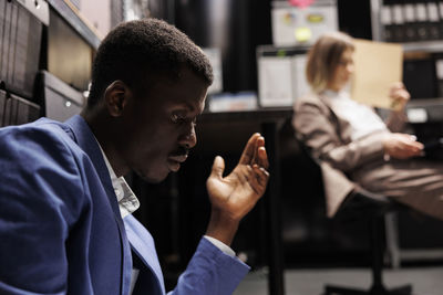 Side view of businessman using mobile phone in gym