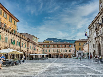 People on street against buildings in city