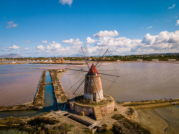 Traditional windmill on land against sky