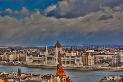 Hungarian parliament virw from fishermans bastion buildings in city against cloudy sky