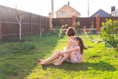 Woman sitting on field against plants