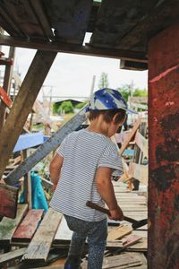 Rear view of a girl standing on wood