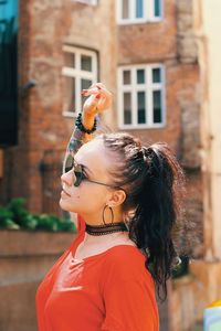 Beautiful young woman wearing sunglasses in city
