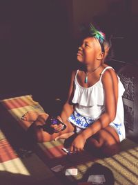 Cute girl sitting on sofa at home