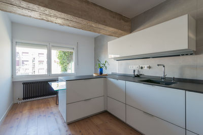 Bright white kitchen with wooden floor