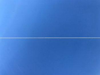 Vapor trail against clear blue sky