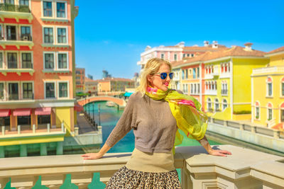 Woman in sunglasses standing against buildings