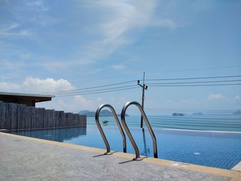 Scenic view of swimming pool by sea against sky