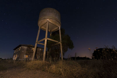 Low angle view of water tower against sky at night