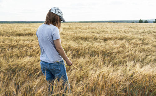 Rear view of woman standing on field