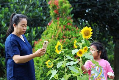 Side view of young woman holding flowers