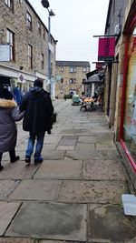 Rear view of woman walking on cobblestone street